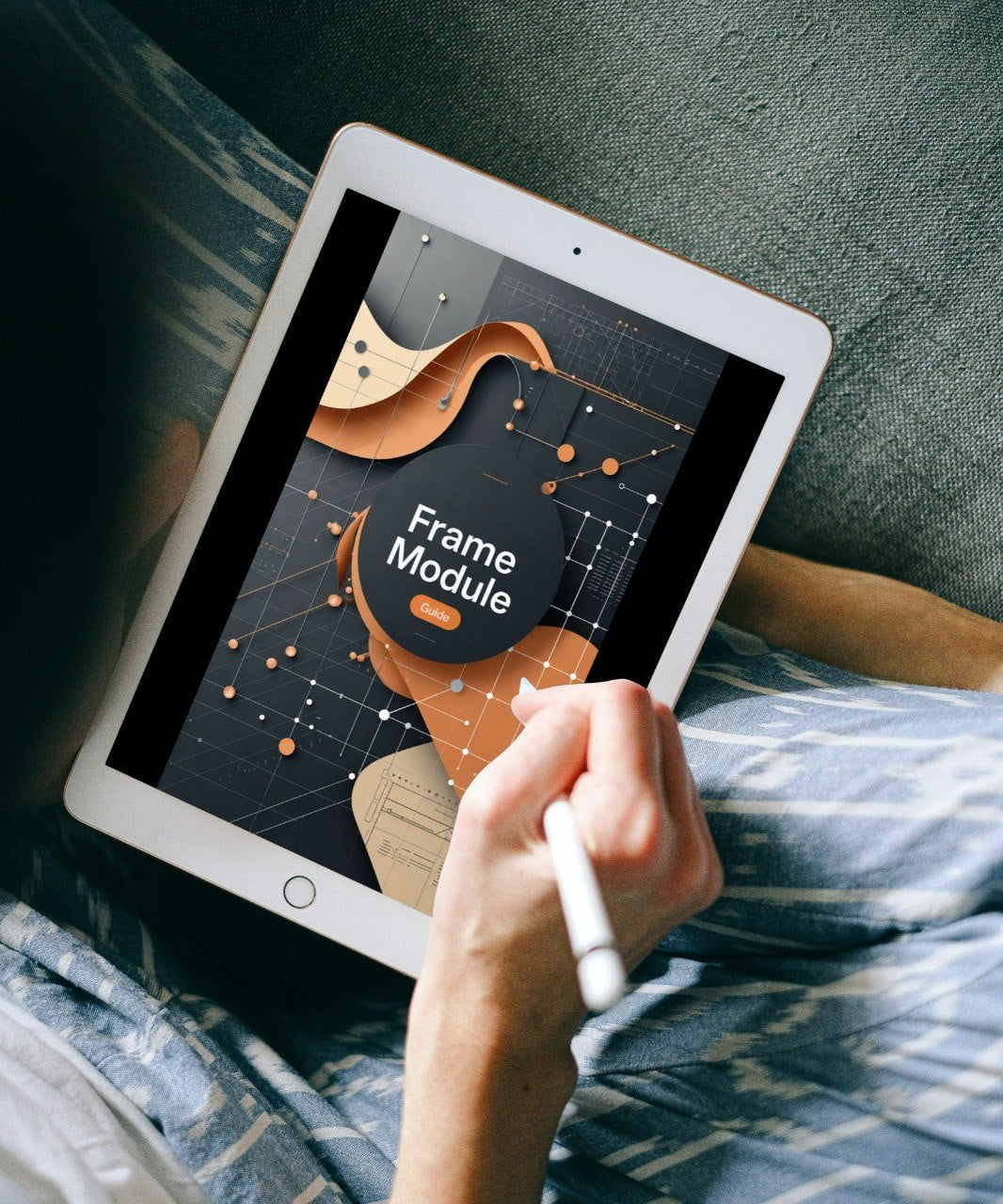 A person lying on a couch holds a white tablet with a stylus, showing a digital graphic design template on the screen that reads 'Frame Module'.
